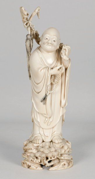 null Beau sujet en ivoire représentant un des Baxian debout sur un rocher sculpté...