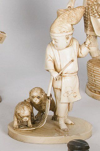null Okimono en ivoire représentant un enfant couronné, observant deux chiots qui...