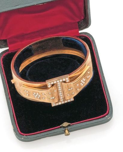 null Bracelet ruban rigide et articulé en or jaune, orné d'un motif stylisé de boucle...