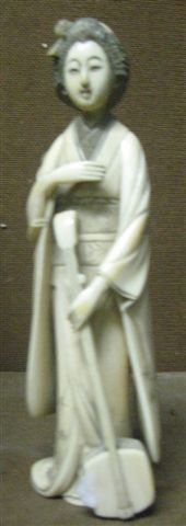 null Sujet en ivoire représentant une geisha et tenant un samisen Japon. Vers 1930....