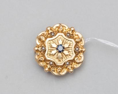 null Broche ronde ancienne en or jaune à décor géométrique centrée d'un saphir rond...