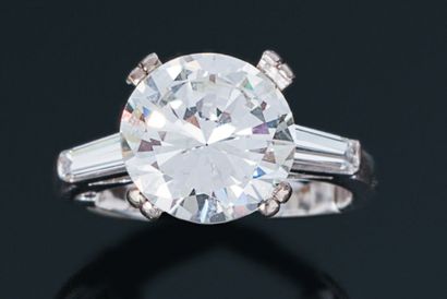 null Bague en or gris 18K (750) ornée d'un diamant taillé en brillant épaulé de deux...