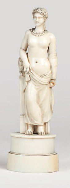 null Statuette en ivoire sculpté figurant une femme vêtue à l'antique, sur un socle....