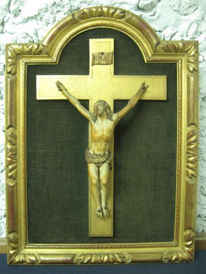 null Christ en ivoire sculpté, dans un cadre en bois doré. XIXe siècle. (manques)....