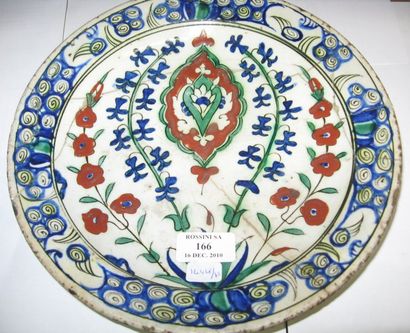 null Plat en faïence, décoré en polychromie et engobe rouge sur fond blanc d'un médaillon...