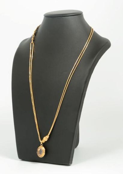 null Un collier en or jaune 18k (750) retenant un médaillon sertie d'améthyste. 

Poids...