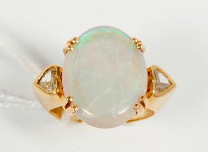 null Bague en or jaune 18k (750) ornée d'une opale épaulée de deux diamants coeur....