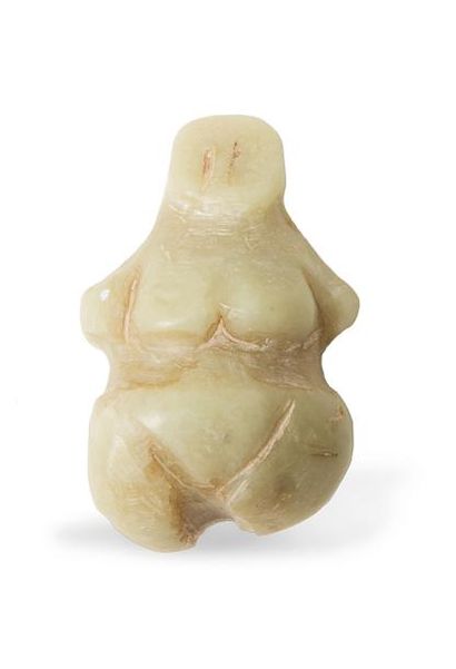 null Figurine représentant une femme nue stylisée, stéatopyge. Percement au niveau...