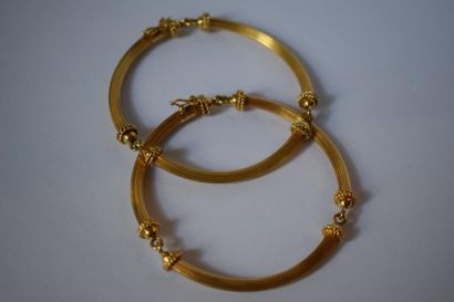 null Deux bracelets en or jaune 18K(750) composés de trois arceaux filetés, les culots...