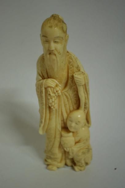 null Okimono en ivoire marin représentant un sage barbu, accompagné d'un enfant....