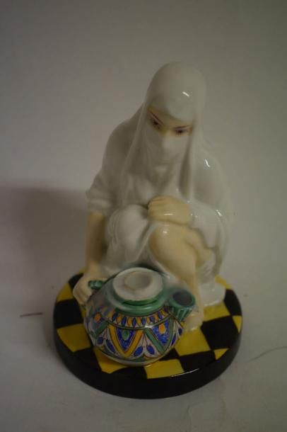 null Un brûle-parfum orientaliste en porcelaine figurant une femme voilée accroupie...