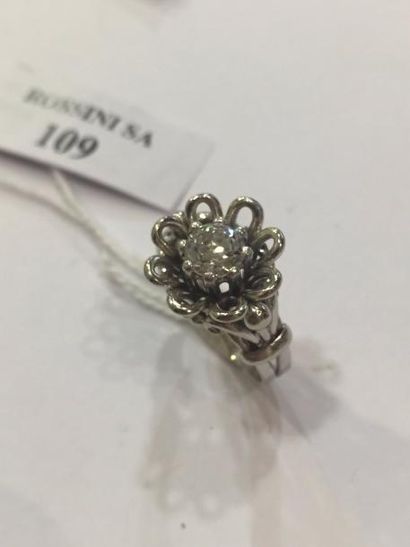  Bague rosace en or gris 18K (750) à filins sertie d'un diamant demi taille (égrisure)....