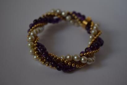 null Bracelet souple en or jaune 18K(750) torsadé de perles de culture et d'améthystes....