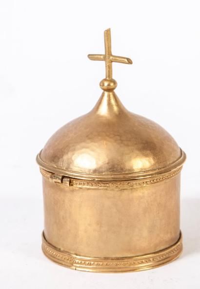 null Un pot à saint chrême en métal doré martellé surmonté d'une croix.

