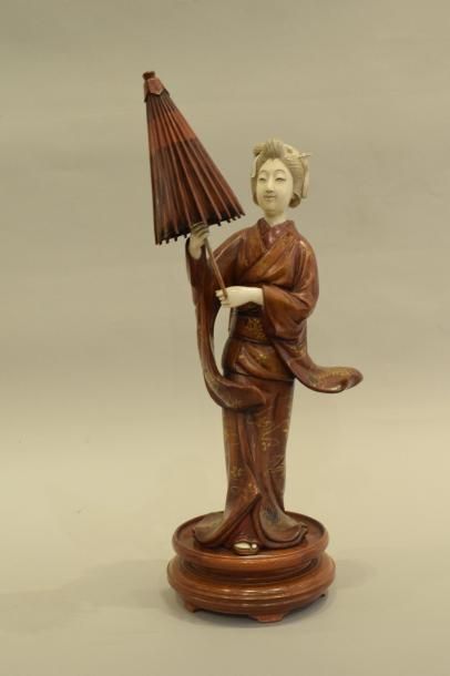 null Okimono en bois et ivoire representant une jeune femme debout tenant une ombrelle,...