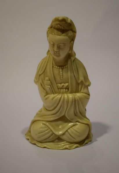 null Bouddha en ivoire sculpté représenté assis, les yeux clos et les mains jointes...