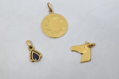 null Lot de trois pendentifs en or 18K (750) représentant une tête de cheval, saint...
