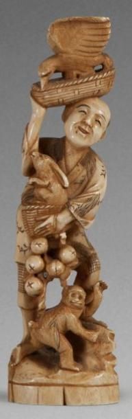 null OKIMONO EN IVOIRE MARIN, représentant un homme accompagné

d’un singe, portant...