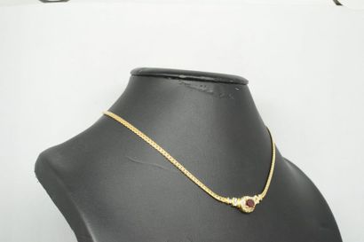 null Collier en or jaune 18K (750) orné dans sa partie frontale d'un rubis ovale...