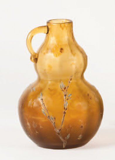Emile GALLE (1846 - 1904) Broc " calebasse " en verre ambré à décor en léger relief...