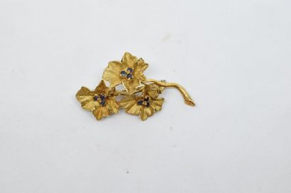 null Broche en or jaune 18k (750) à décors de trois fleurs, les pistils en saphir...