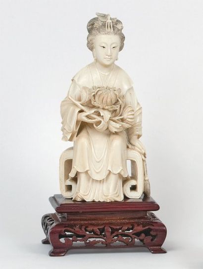 null Femme assise tenant une branche de pivoinier, en ivoire. Chine. H.: 18,5 cm...