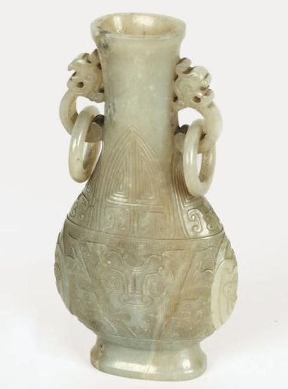 null Petit vase de forme hu aplati en jade néphrite céladon, à décor archaïsant sculpté...