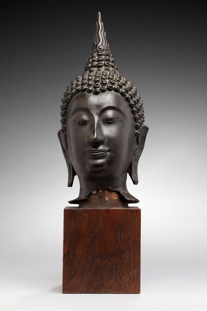 null Tête de Bouddha en bronze, l'Ushnisha surmontée de sa flamme. 

Sur socle en...