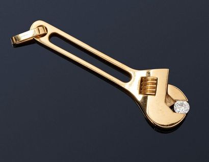 null 

Pendentif en or jaune 18K (750) stylisé d'une clé à mollette enserrant un...