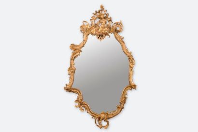 null Grand miroir rocaille en bois sculpté d'agrafes et coquilles surmonté d'une...