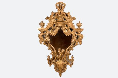 null Miroir à parecloses en bois sculpté et doré, de forme violonée ornée de rinceaux...