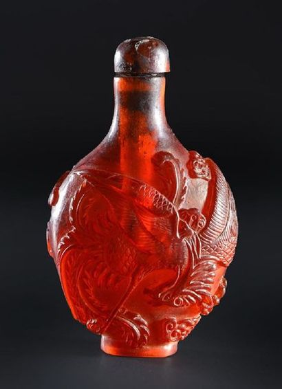 null CHINA.
Synthetic amber resin carved with a dragon and a phoenix chasing the...