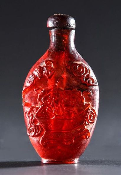 null CHINA.
Synthetic amber resin snuff bottle carved with bats flying over a flower...