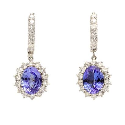 null A pair of 14K white gold earrings each set with oval tanzanites in a brilliant-cut...