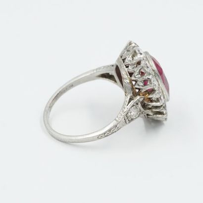 null Platinum ring, set with a cushion-cut ruby in a setting of 12 brilliant-cut...