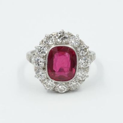 null Platinum ring, set with a cushion-cut ruby in a setting of 12 brilliant-cut...