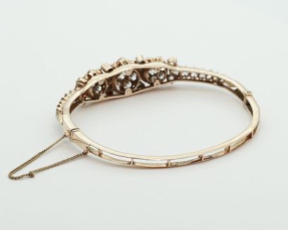 null 
Opening bracelet in 14K yellow gold with a central motif decorated with flowers...