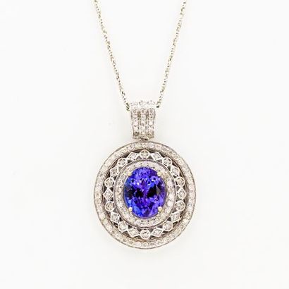 null 14K white gold pendant and chain, set with an oval tanzanite in a triple border...