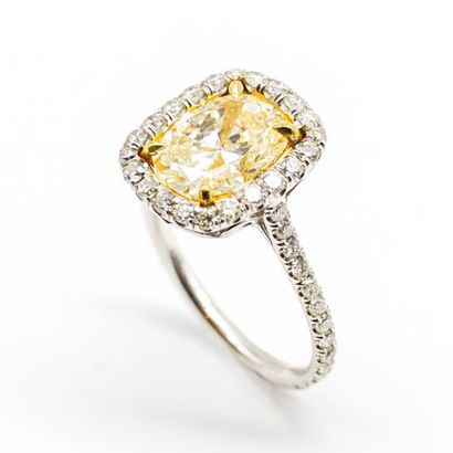 null An 18K white gold ring with a yellow oval-cut diamond set in brilliant-cut diamonds.



Size:...