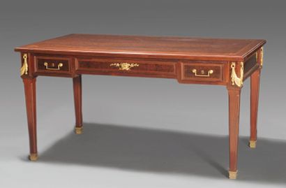 KRIEGER Bureau plat de style Louis XVI ouvrant par trois tiroirs. Le bois d'acajou...