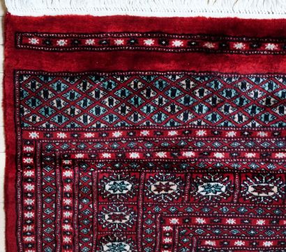 null Boukara rug with circular patterns on a red background, handwoven in Pakistan,...