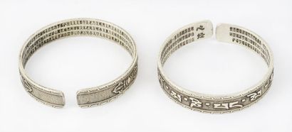  CHINE / CHINA 
Paire de bracelet en métal argenté présentant des inscriptions rituelles....