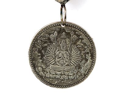  GUANYIN 
Pendentif en métal argenté mettant en scène Guanyin (Avalokitesvara). 
...