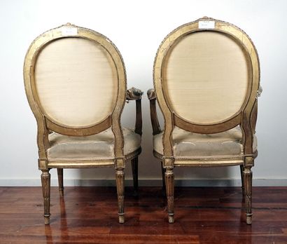 null Paire de fauteuils aux dossiers à médaillon en bois doré, de style Louis XVI...