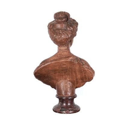 null Terracotta bust on a marble base representing a woman in dress. Her hair is...