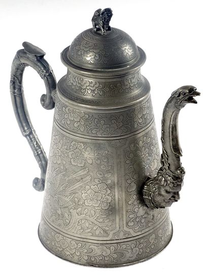 A pewter jug ​​decorated with flowers, birds...