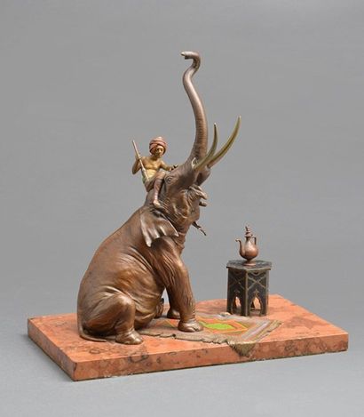 null 
Cornac et son éléphant assis en bronze polychrome, la trompe levée, il repose...