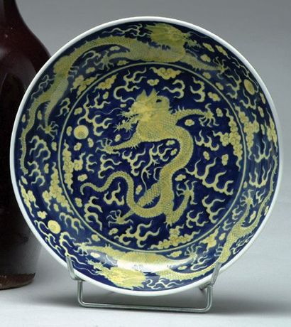 null Plat en porcelaine de Chine à décor de dragons jaunes sur fond bleu. Chine Chinese...