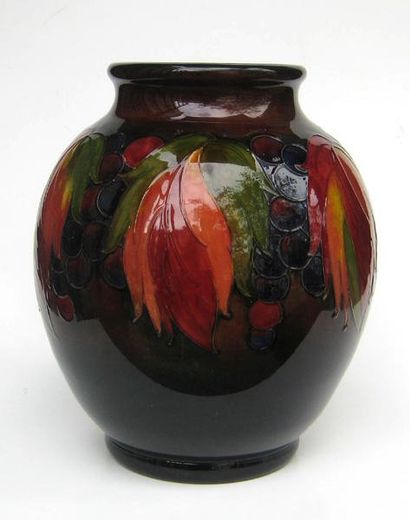 MOORCROFT Vase en porcelaine anglaise polychrome à décor de feuilles et de fruits....