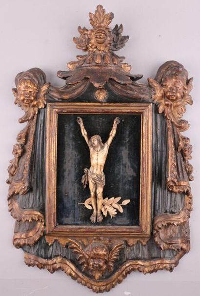 null Christ en croix en ivoire dans un cadre en bois doré richement sculpté d'angelots,...
